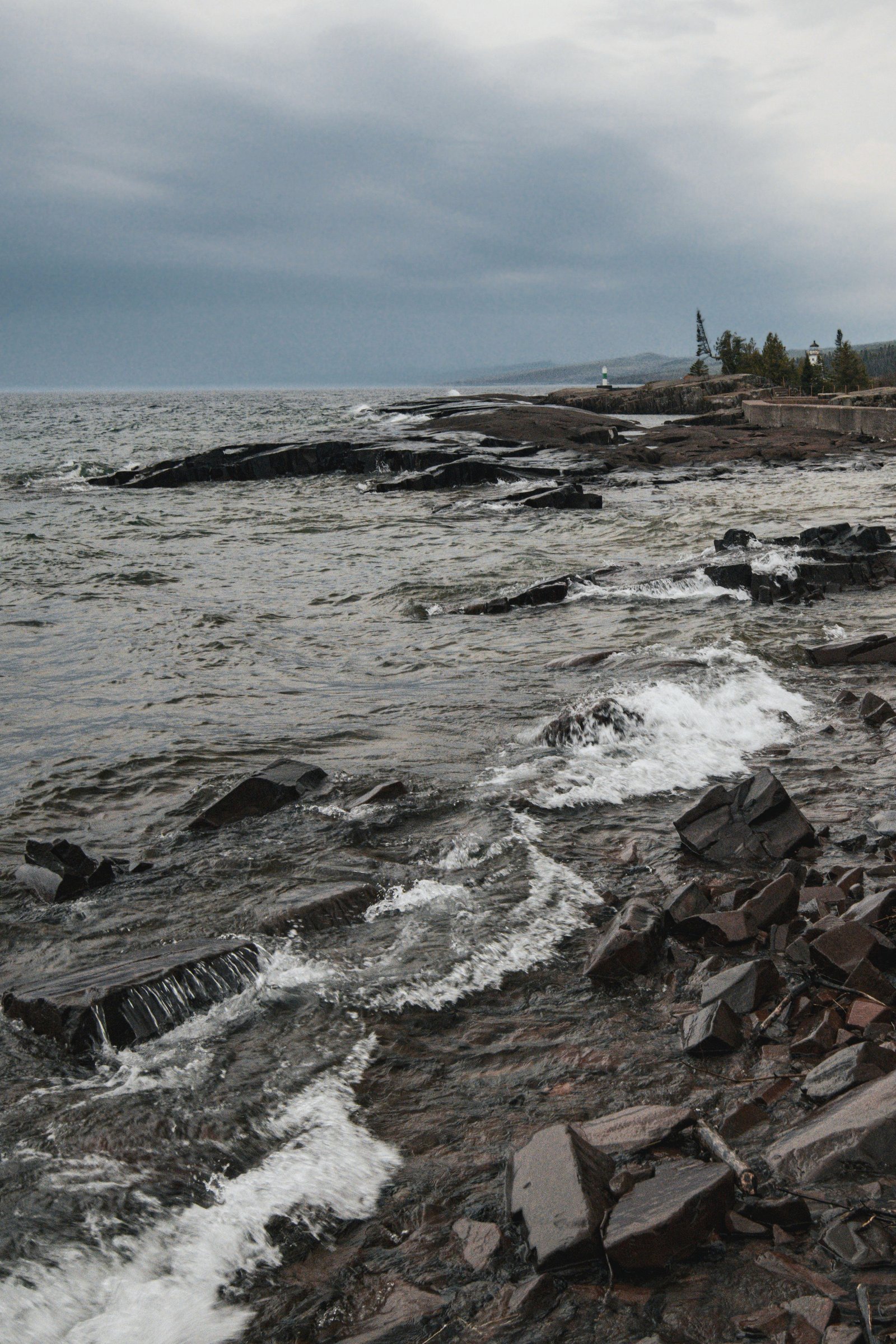 Waves breaking on Lake Superior's rocky Minnesota shore under a low sky.